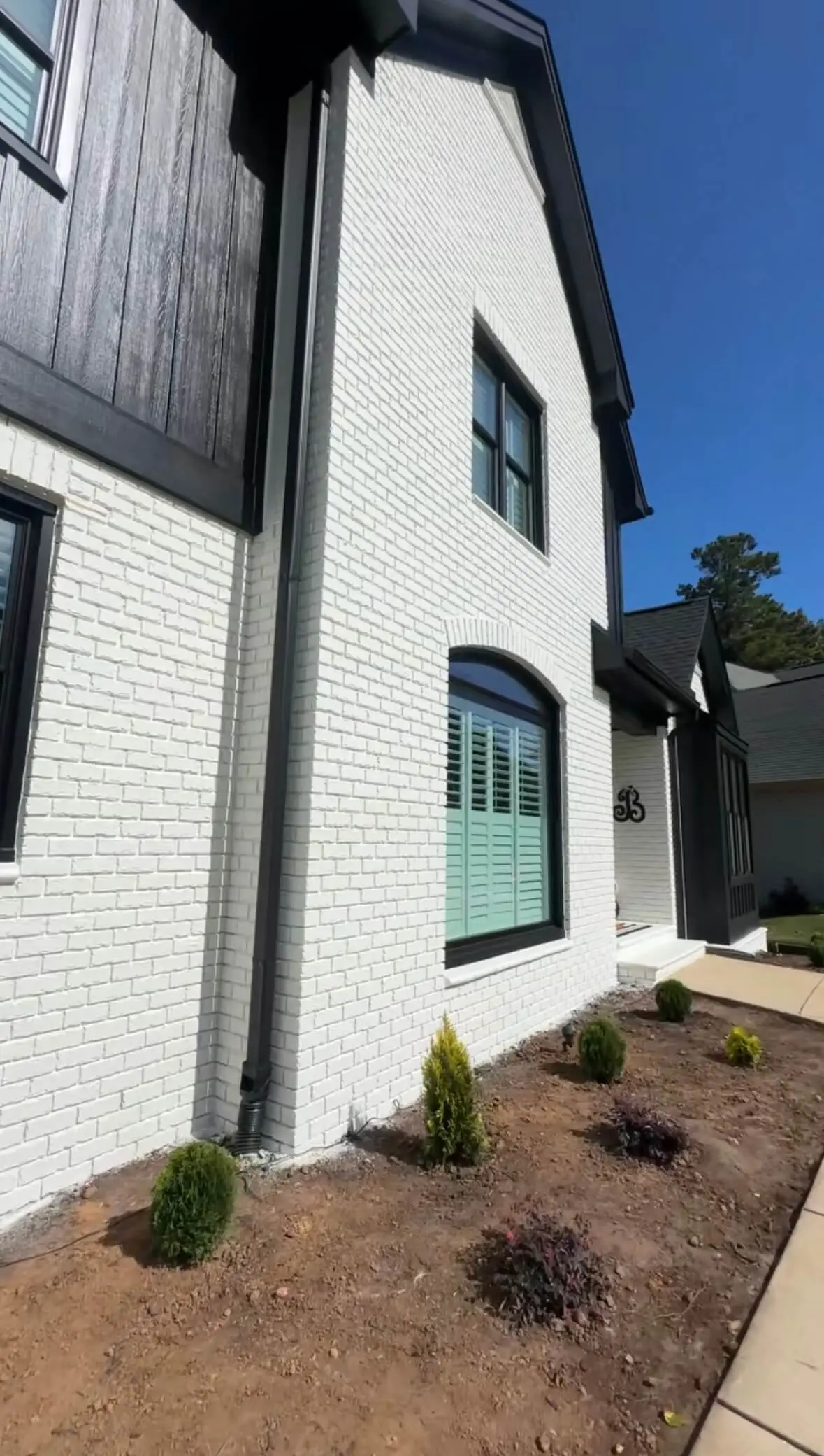 Freshly painted white brick exterior of a modern home with black trim – professional exterior painting services in North Carolina.
