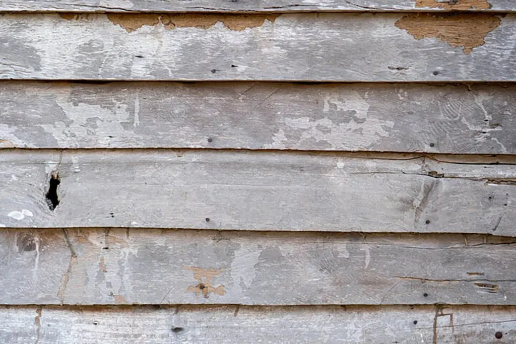 Weathered deck boards showing peeling stain and gray wood in need of refinishing