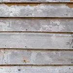 Weathered deck boards showing peeling stain and gray wood in need of refinishing