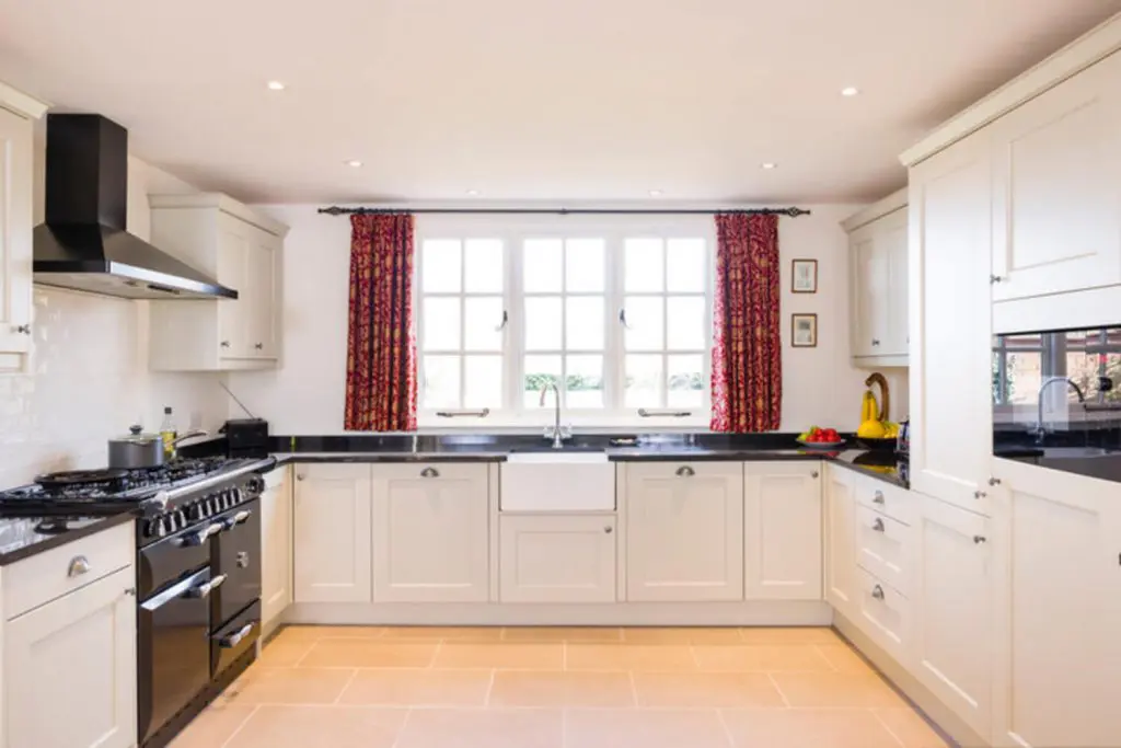 Bright kitchen with professionally painted white shaker cabinets and dark countertops