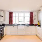 Bright kitchen with professionally painted white shaker cabinets and dark countertops