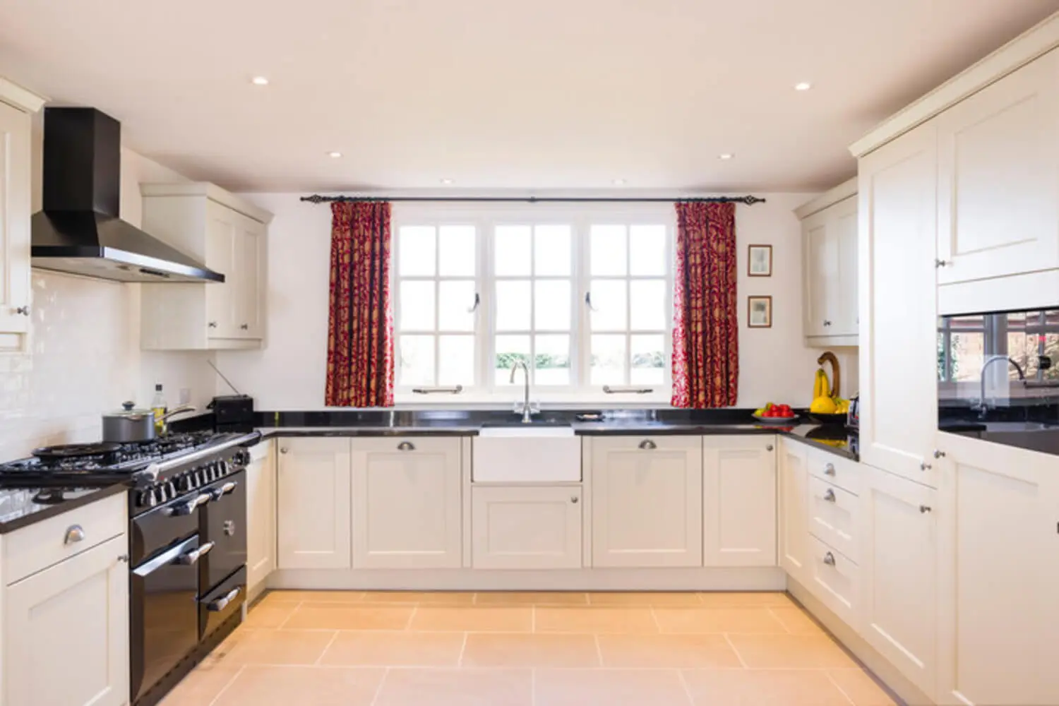 Bright kitchen with professionally painted white shaker cabinets and dark countertops